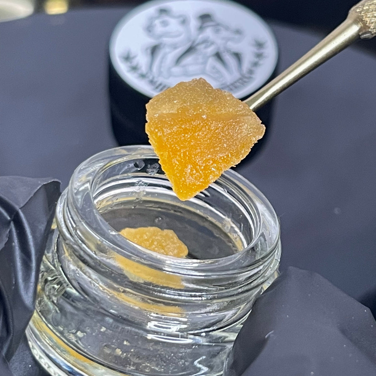 STRAWBERRY COUGH × OG KUSH, crumble CBD HempBrothers — crumble présenté avec une spatule au-dessus du pot